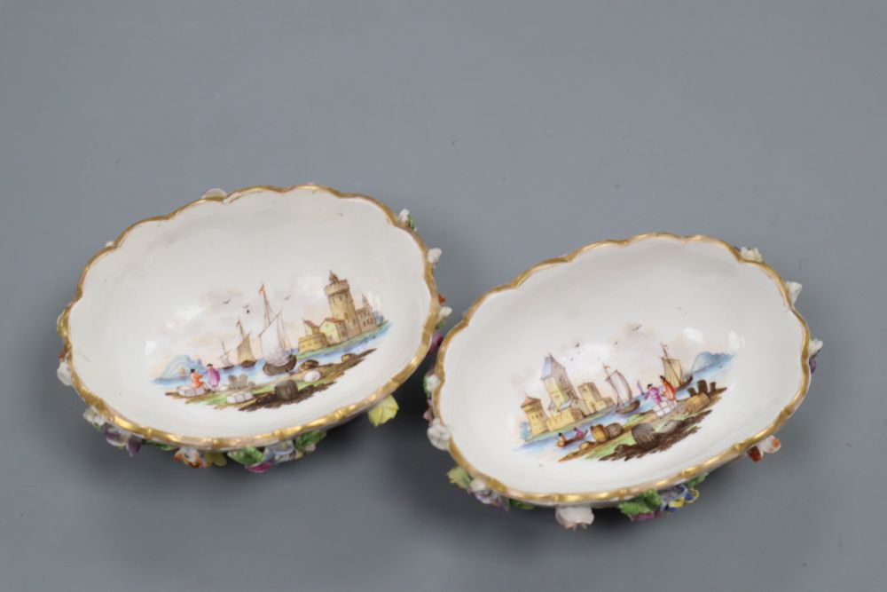 A pair of Helena Wolfsohn Dresden oval basket moulded salts, painted with harbour scenes and encrusted with flowers